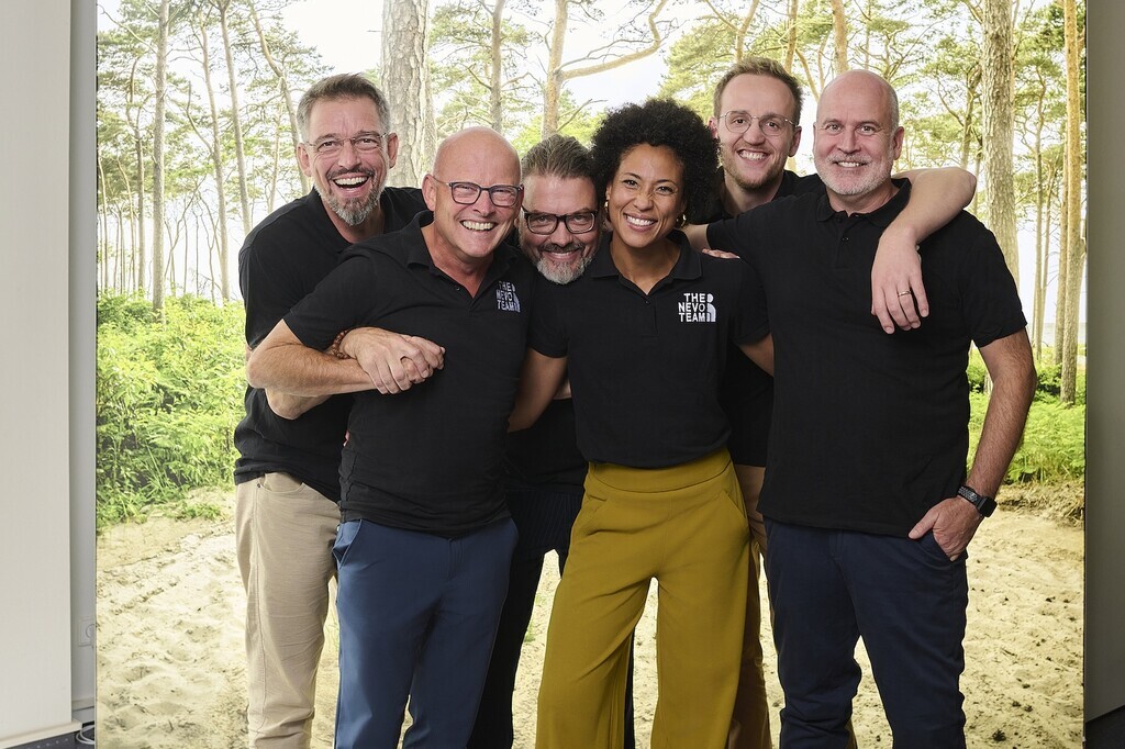 "das nevo Team steht in freudiger Umarmung eng beieinander"